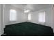 Bright bedroom with three large windows, a ceiling fan, and dark green carpet at 19007 N 79Th Dr, Glendale, AZ 85308