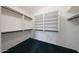 Walk-in closet featuring shelves, wooden poles, and dark green carpet at 19007 N 79Th Dr, Glendale, AZ 85308
