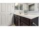 Bathroom features a single sink vanity with dark wood cabinets and ample lighting at 21014 W Ridge Rd, Buckeye, AZ 85396