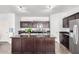 Well-designed kitchen features dark wood cabinets, stainless appliances and a granite island with sink at 21014 W Ridge Rd, Buckeye, AZ 85396