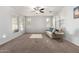 Bright living room featuring carpeted floors, a ceiling fan, and a cozy seating area at 21014 W Ridge Rd, Buckeye, AZ 85396