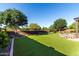 Oversized backyard with artificial turf, an outdoor firepit area, mature trees, and a private setting at 21022 E Arroyo Verde Ct, Queen Creek, AZ 85142