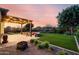 Backyard featuring a pergola with string lights, seating, grassy area, and fire pit at 21022 E Arroyo Verde Ct, Queen Creek, AZ 85142