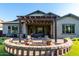 Inviting backyard boasting artificial turf, a custom fire pit seating area, and a covered patio at 21022 E Arroyo Verde Ct, Queen Creek, AZ 85142