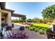 Lovely backyard with synthetic grass, custom fire pit, covered patio, and mature landscaping for privacy at 21022 E Arroyo Verde Ct, Queen Creek, AZ 85142
