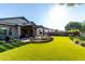 Lush backyard features an outdoor kitchen, a custom firepit area, artificial grass, and professional landscaping at 21022 E Arroyo Verde Ct, Queen Creek, AZ 85142