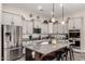 A kitchen showcasing a large granite island with seating, stainless steel appliances, and custom gray cabinetry at 21022 E Arroyo Verde Ct, Queen Creek, AZ 85142