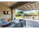 Relaxing covered patio with stylish furniture, a TV, and views of the backyard's lush landscaping at 21022 E Arroyo Verde Ct, Queen Creek, AZ 85142