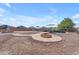Desert landscaped backyard with an outdoor kitchen, inground pool, and fire pit at 23886 W Harrison Dr, Buckeye, AZ 85326