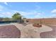An inviting backyard with a pool, fire pit, dining area, and lush desert landscaping at 23886 W Harrison Dr, Buckeye, AZ 85326