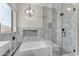 Modern bathroom with a glass-enclosed shower, soaking tub, and marble tile at 23886 W Harrison Dr, Buckeye, AZ 85326