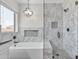 Bathroom featuring a bathtub, a shower, marble tiling, and light fixtures at 23886 W Harrison Dr, Buckeye, AZ 85326