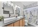 Modern bathroom featuring double sinks, stylish mirrors, and a tiled shower area at 23886 W Harrison Dr, Buckeye, AZ 85326