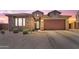 Charming single-story home with stone accents, a two-car garage, and desert landscaping at sunset at 23886 W Harrison Dr, Buckeye, AZ 85326