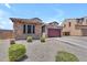 Single-story home with stone accents, desert landscaping, and a two-car garage on a sunny day at 23886 W Harrison Dr, Buckeye, AZ 85326
