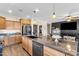 This kitchen has wooden cabinets, granite countertops, a dishwasher, and a large island at 23886 W Harrison Dr, Buckeye, AZ 85326