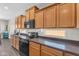 This kitchen has wooden cabinets, dark countertops, an oven, and a microwave oven at 23886 W Harrison Dr, Buckeye, AZ 85326