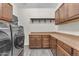Laundry room featuring front-loading washer/dryer and ample cabinet space for storage at 23886 W Harrison Dr, Buckeye, AZ 85326