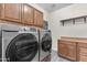 Laundry room featuring front-loading washer/dryer and ample cabinet space for storage at 23886 W Harrison Dr, Buckeye, AZ 85326