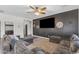 Comfortable living room with plush seating, a ceiling fan, and a statement wall featuring a large television at 23886 W Harrison Dr, Buckeye, AZ 85326