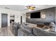 Cozy living room with plush seating, a ceiling fan, and a statement wall featuring a large television at 23886 W Harrison Dr, Buckeye, AZ 85326