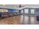 Spacious living room featuring a long leather couch, ceiling fan, and lots of natural light at 23886 W Harrison Dr, Buckeye, AZ 85326