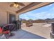 A covered patio with ceiling fan overlooks the expansive backyard and outdoor kitchen at 23886 W Harrison Dr, Buckeye, AZ 85326