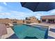 Backyard pool and patio with outdoor dining, grilling station, and privacy wall at 23886 W Harrison Dr, Buckeye, AZ 85326