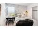 Cozy bedroom with a comfortable bed, fun wallpaper and a dedicated workspace area by the window at 25082 N 174Th Ln, Surprise, AZ 85387