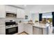 Modern kitchen featuring white cabinets, stainless steel appliances, and an eat-in island at 25082 N 174Th Ln, Surprise, AZ 85387