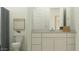 Modern bathroom features a gray shower curtain, white cabinets and toilet, and neutral-toned decor at 25162 N 177Th Dr, Surprise, AZ 85387