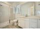 Bright bathroom featuring a glass-enclosed shower, white cabinets, and a large mirror at 25162 N 177Th Dr, Surprise, AZ 85387