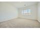 Light-filled bedroom featuring a window, neutral carpeting, and plenty of space at 25162 N 177Th Dr, Surprise, AZ 85387