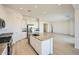 Open kitchen with an island, stainless steel appliances and white cabinets leading to the living area at 25162 N 177Th Dr, Surprise, AZ 85387