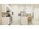 Well-appointed kitchen features stainless steel appliances, modern white cabinets, an island with seating, and sleek pendant lighting at 25162 N 177Th Dr, Surprise, AZ 85387