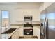 Well-appointed kitchen boasts stainless steel appliances, white cabinets, and modern fixtures at 25162 N 177Th Dr, Surprise, AZ 85387