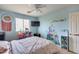 A bright bedroom featuring a ceiling fan, wall art, and a large window for natural light at 2531 W Saint Catherine Ave, Phoenix, AZ 85041