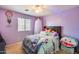 Bright purple bedroom with a decorated bed, canopy, and window with blinds at 2531 W Saint Catherine Ave, Phoenix, AZ 85041