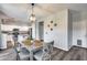Bright dining area with gray wood table, pendant lighting, and adjacent kitchen with stainless steel appliances at 2531 W Saint Catherine Ave, Phoenix, AZ 85041