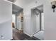 Hallway featuring access to a bathroom and laundry room, with neutral wall paint and wood flooring at 2531 W Saint Catherine Ave, Phoenix, AZ 85041