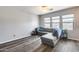 Bright living room featuring a gray sectional sofa, large windows, and wood-look flooring at 2531 W Saint Catherine Ave, Phoenix, AZ 85041