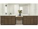 Bathroom vanity features dual sinks, wood cabinets, quartz counters, and a makeup counter with a chair at 25437 N 176Th Ave, Surprise, AZ 85387