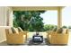 Outdoor seating area with wicker chairs, yellow pillows, and a dark blue coffee table overlooking the yard at 25437 N 176Th Ave, Surprise, AZ 85387