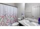 Bathroom boasts a sink, toilet, shower, and floral shower curtain at 2704 S 172Nd Ln, Goodyear, AZ 85338