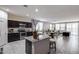Open-concept kitchen featuring dark wood cabinets, stainless steel appliances, granite countertops, and a view of the dining area at 2704 S 172Nd Ln, Goodyear, AZ 85338
