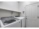 Functional laundry room equipped with modern washer, dryer, shelving, and convenient access to the exterior at 2704 S 172Nd Ln, Goodyear, AZ 85338