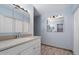 Bright bathroom with a vanity, large mirrors, and wood-look floors at 2726 W Meseto Cir, Mesa, AZ 85202