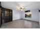 Spacious bedroom featuring wood flooring, a ceiling fan, and a large window at 2726 W Meseto Cir, Mesa, AZ 85202