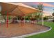 Community playground with swings, slides, shade structure, and green lawn at 2726 W Meseto Cir, Mesa, AZ 85202