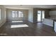 Open-concept living room with wood-look floors, access to patio, and view to the kitchen, with ample natural light at 3363 S 180Th Ln, Goodyear, AZ 85338